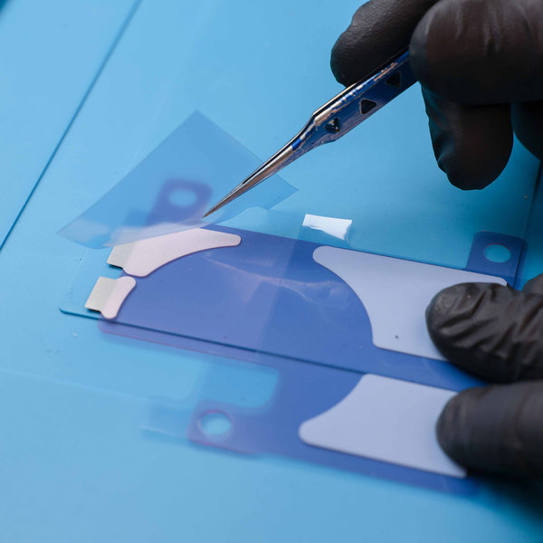 Applying the adhesive strips on new battery